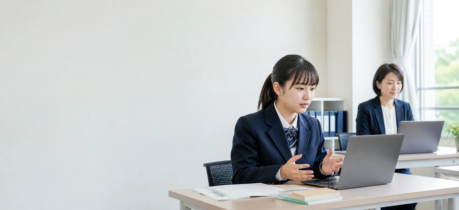 生徒がパソコンで面接練習をし、先生が見守っている